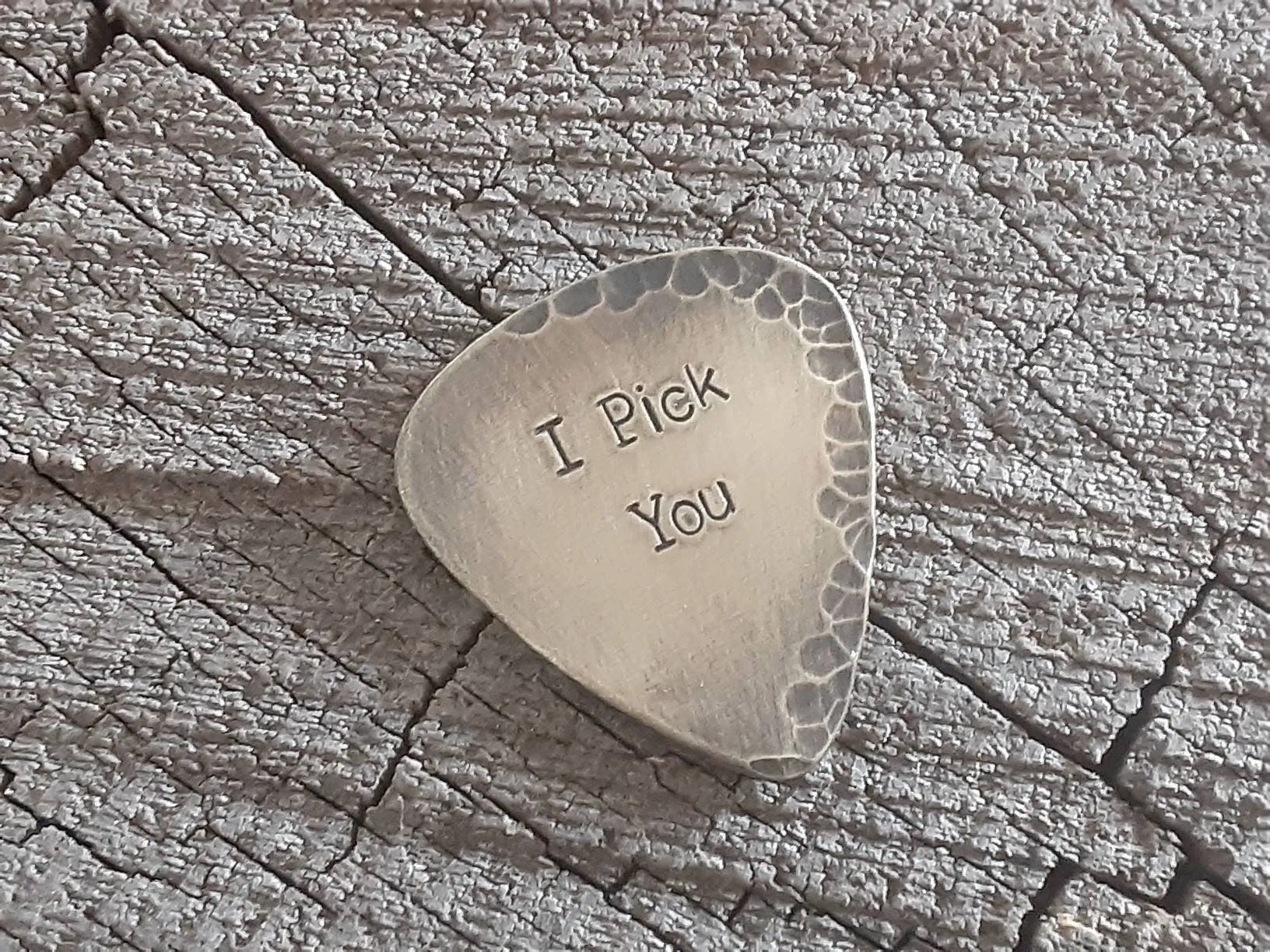 Brass guitar pick with a distressed finish