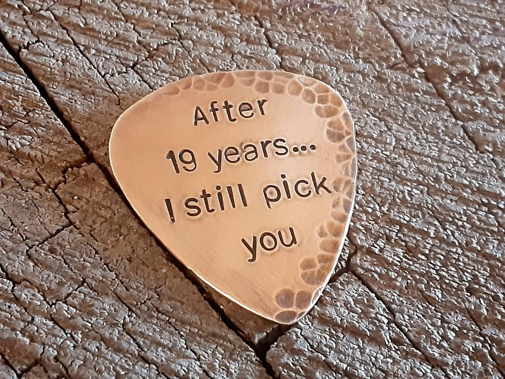 Bronze guitar pick with distressed rustic finishes