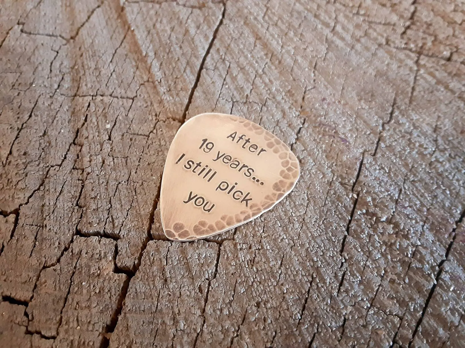 Bronze guitar pick with distressed rustic finishes