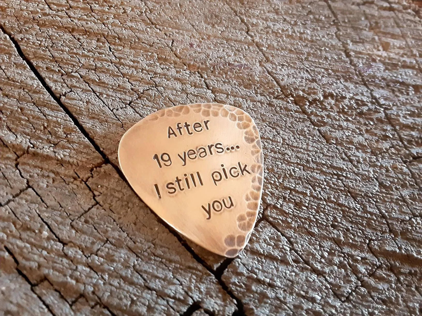 Bronze guitar pick with distressed rustic finishes